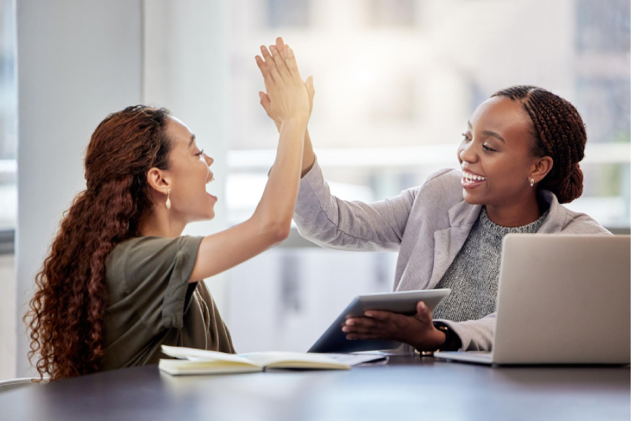 I couldnt have done it without you shot of two young female colleagues giving each other a high five in an office at work